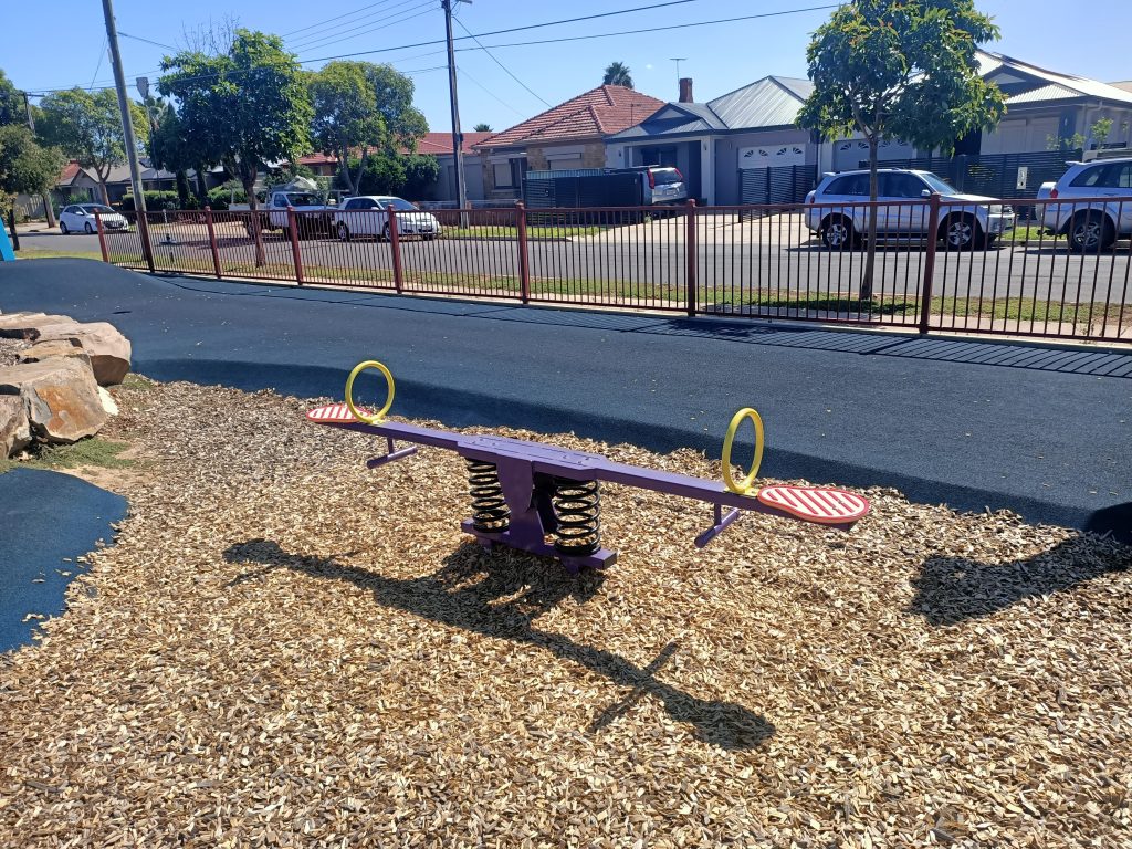 Purple seesaw Woodville Gardens Street In Background